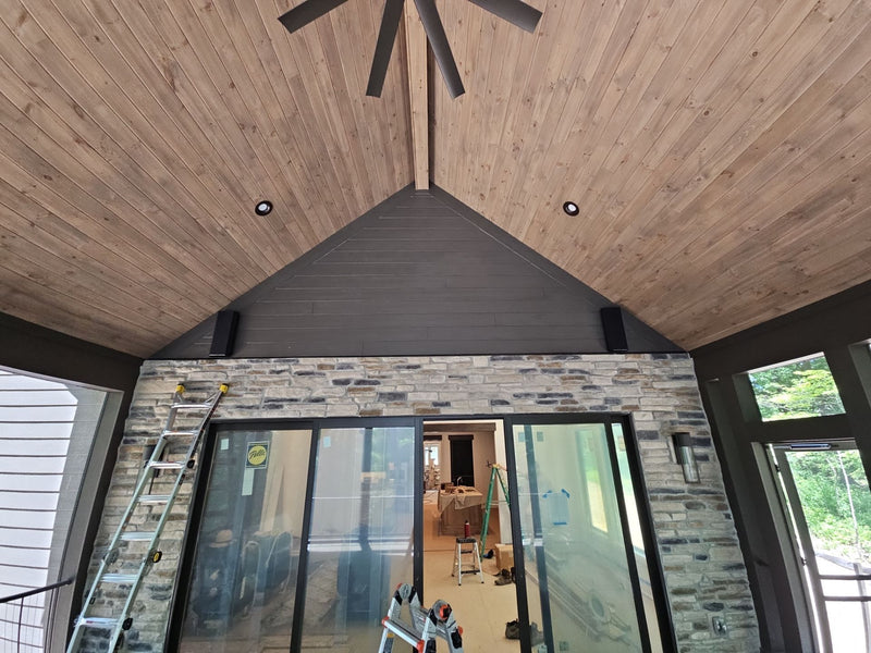 Vaulted great room with a stone fireplace wall