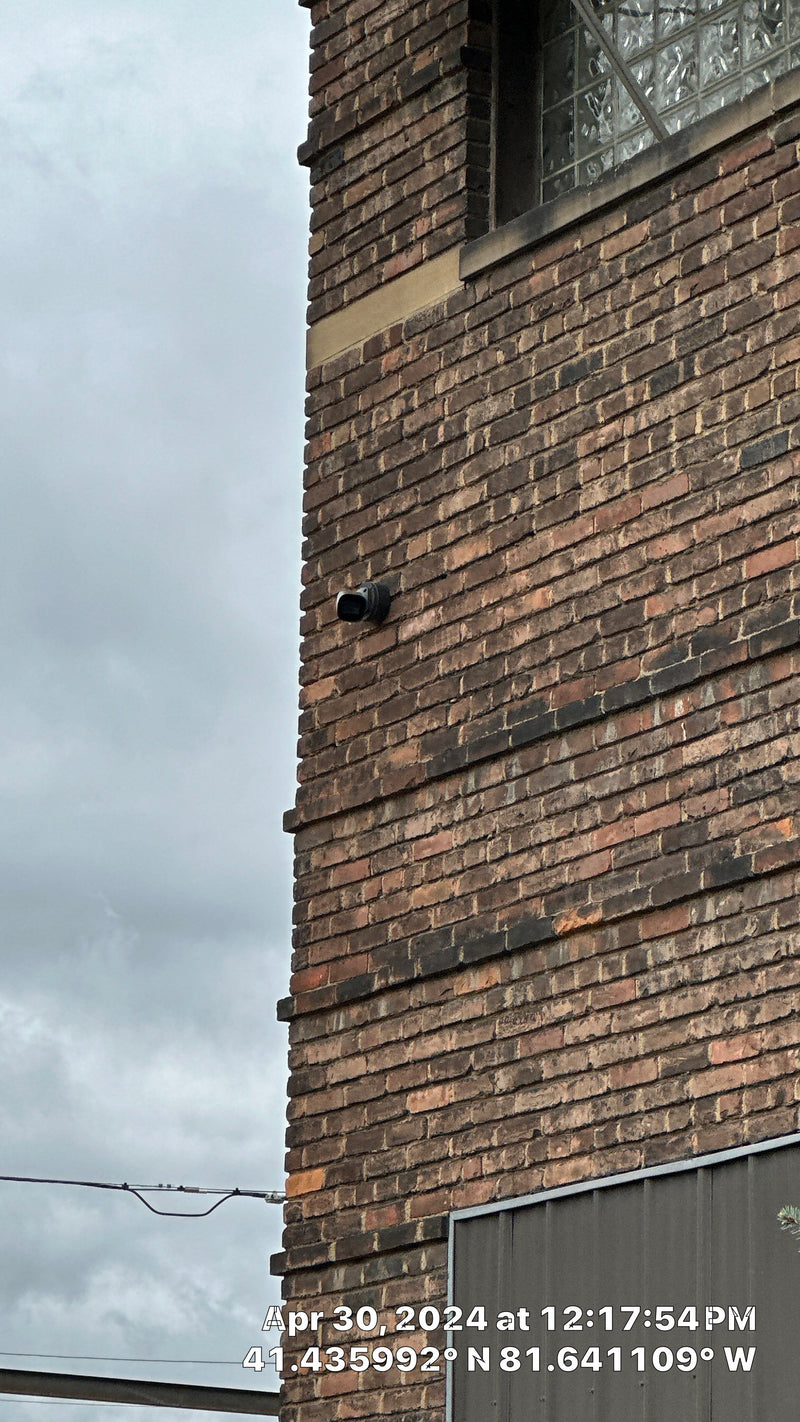 Camera mounted high on a brick wall