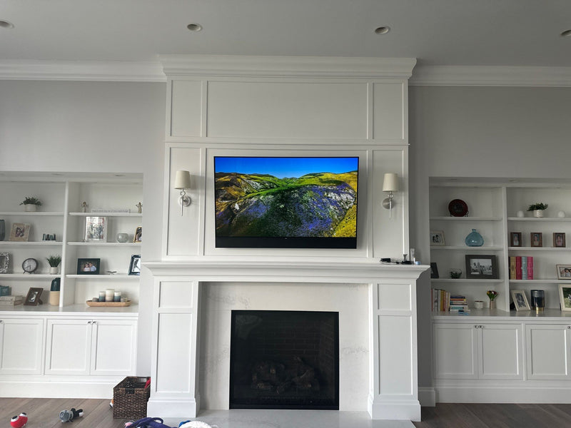 TV above a white fireplace with built-in shelving