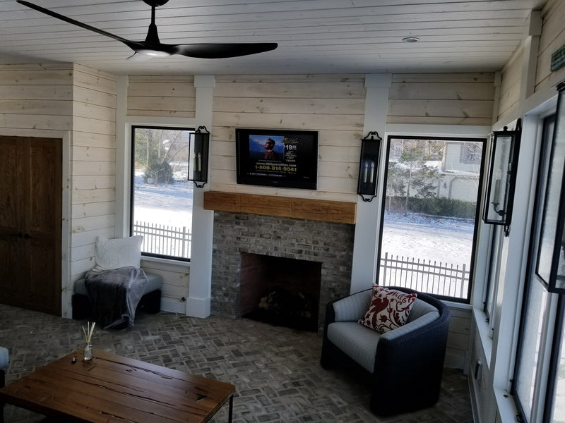Living room with TV above a fireplace
