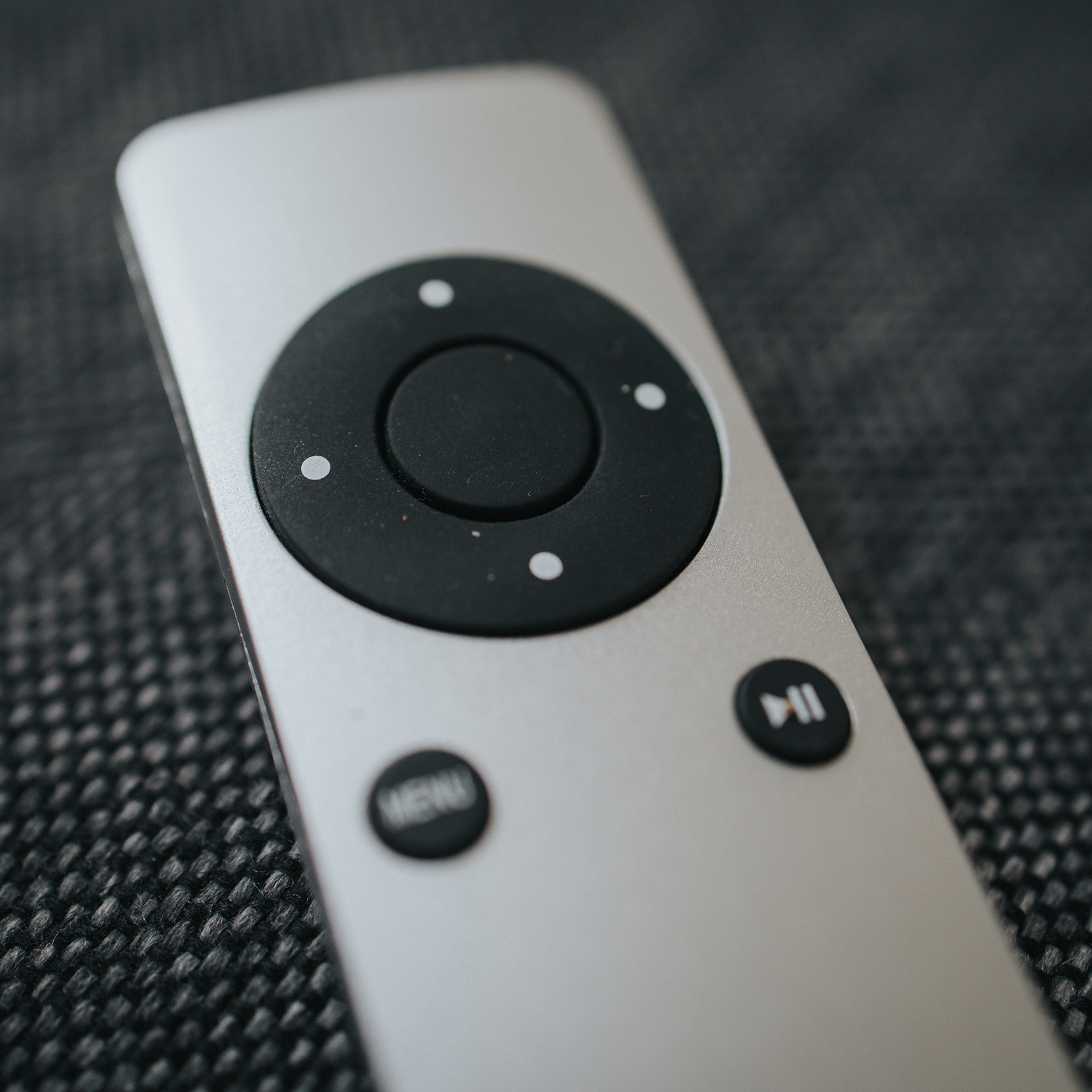 Close-up of a remote control on a textured surface