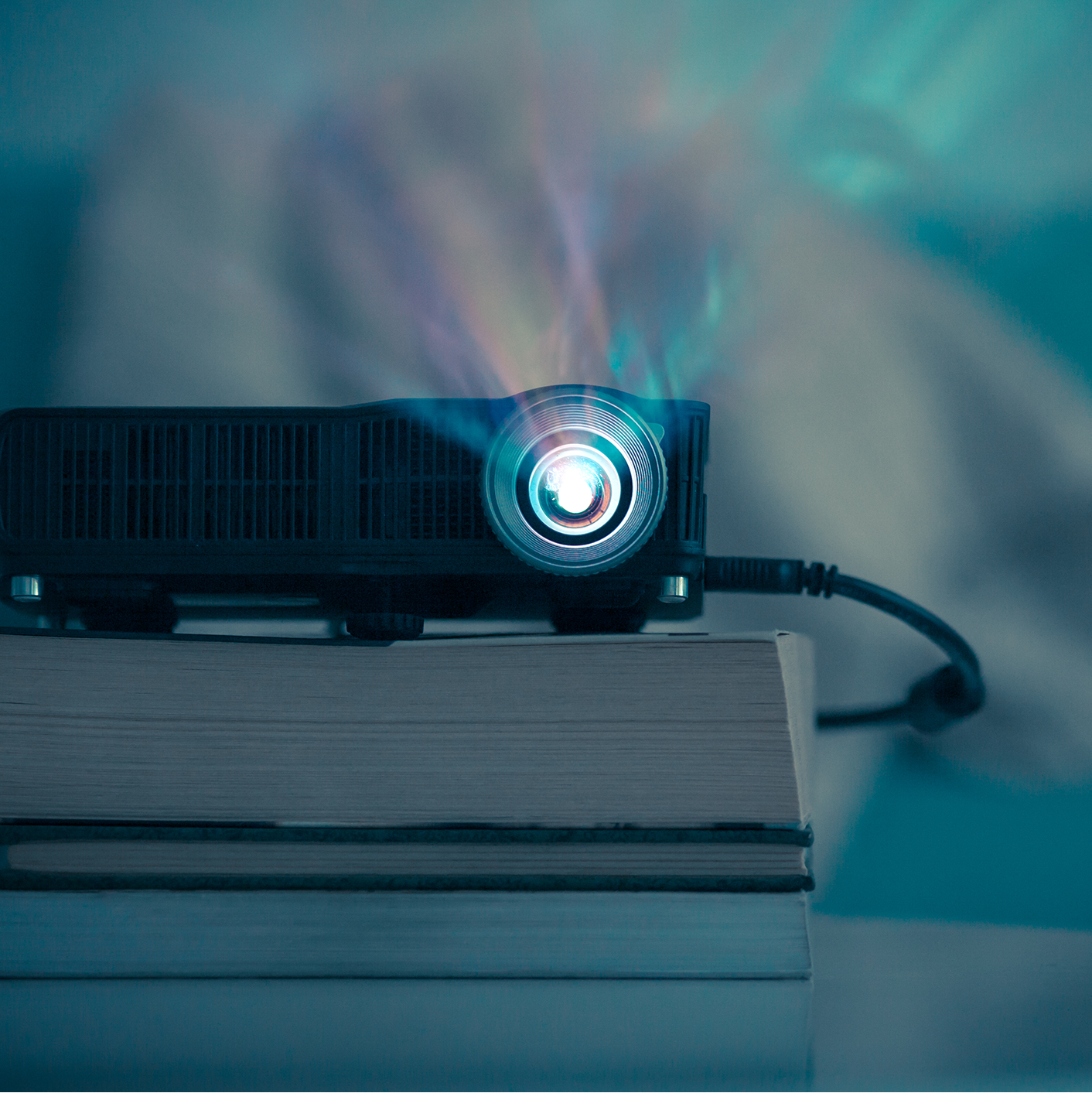 Projector on a stack of books with a blue tint