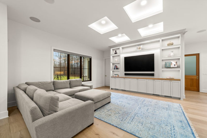 Family room with TV above a two-sided fireplace